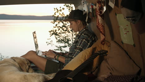 Woman-Using-Laptop-in-Van-at-Sunset-on-Lakeside